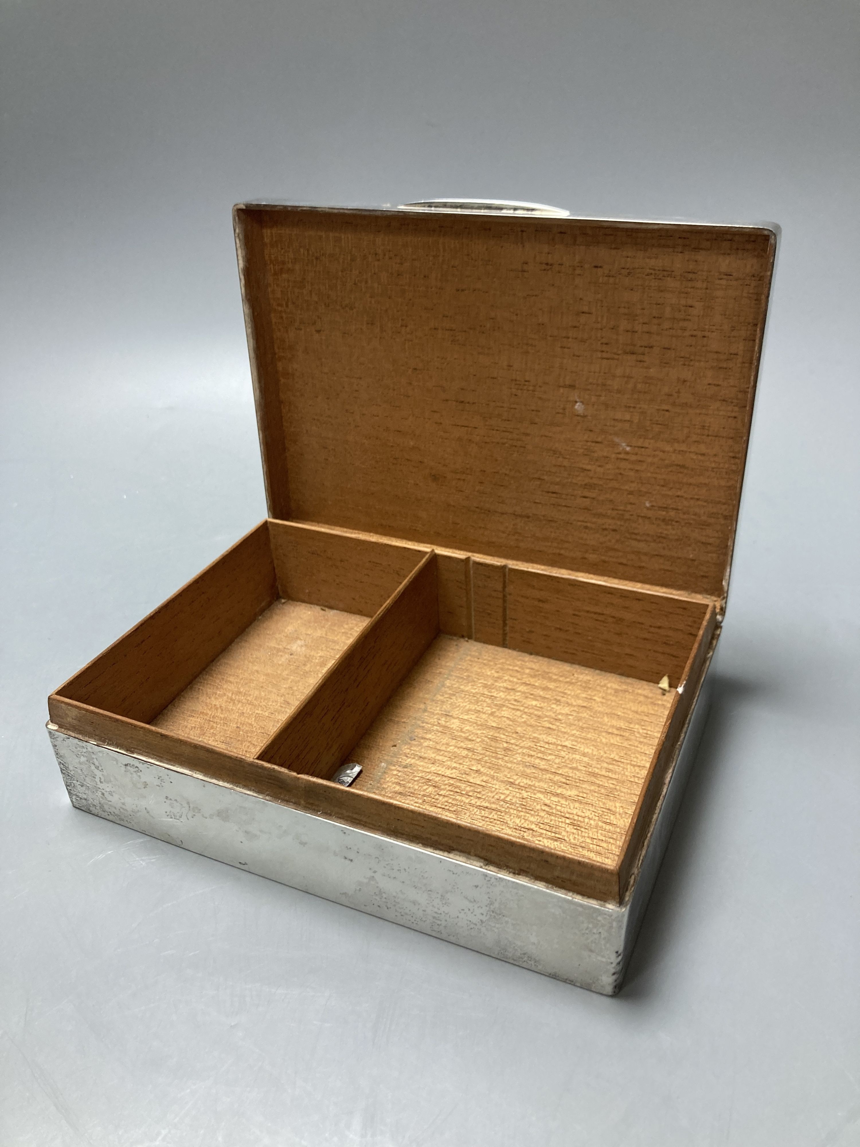 A silver cigar box, London 1928, 18cm, a silver ring box, Birmingham 1925, 9 cm diameter, and a silver topped pin box, 8.5 cm wide